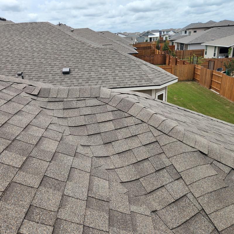 Asphalt shingles on roof with lifting edges sealed Asphalt shingles on roof with lifting edges sealed