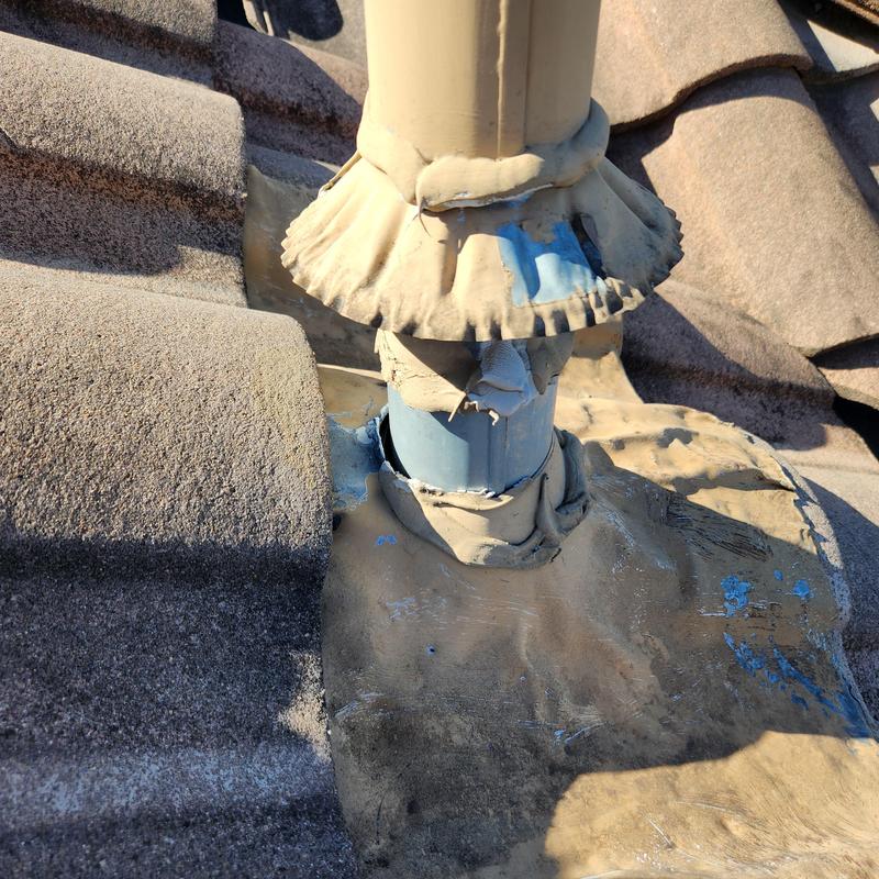 Roof vent flashing with damaged sealant on tile roof Roof vent flashing with damaged sealant on tile roof