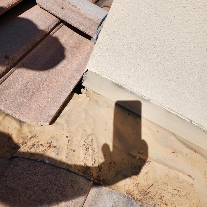 Roof tile with damaged flashing and sealant gap Roof tile with damaged flashing and sealant gap