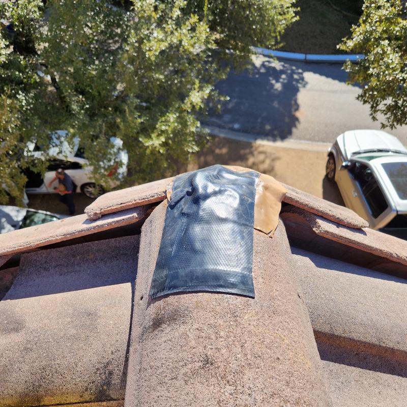 Roof ridge tile with temporary patch tape Roof ridge tile with temporary patch tape