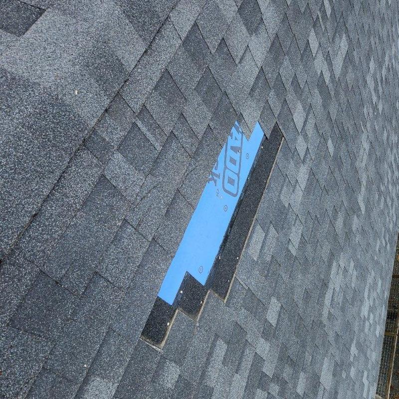 Charcoal black roof shingles with exposed underlayment Charcoal black roof shingles with exposed underlayment