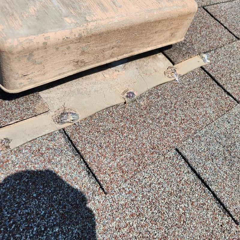 Roof shingles near vent with sealed patches and caulking Roof shingles near vent with sealed patches and caulking