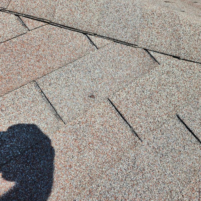 3-tab shingles with nail visible on roof surface 3-tab shingles with nail visible on roof surface