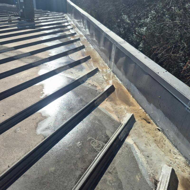 Metal roof wall tie-in with coating prep work