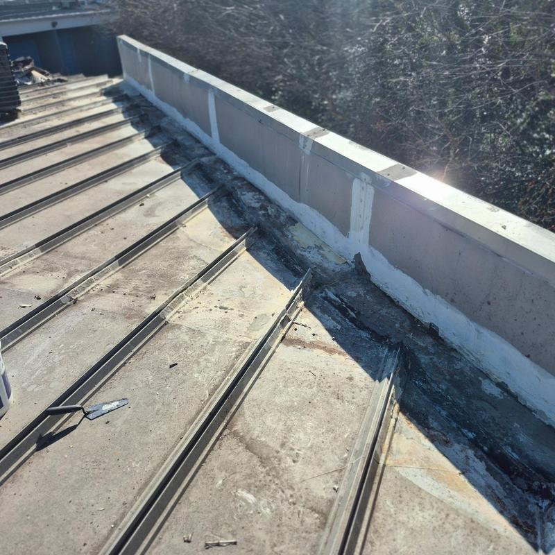 Metal roof wall tie-in with fluid-applied coating