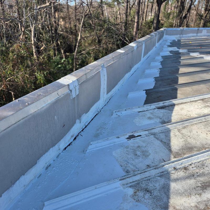 Metal roof wall tie-in with fluid-applied coating