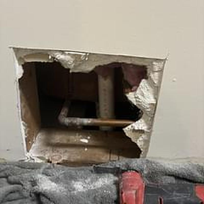 Tub drain pipe inspection behind drywall opening
