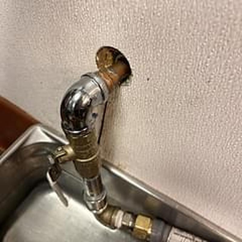 Copper water pipe leak inspection at commercial sink