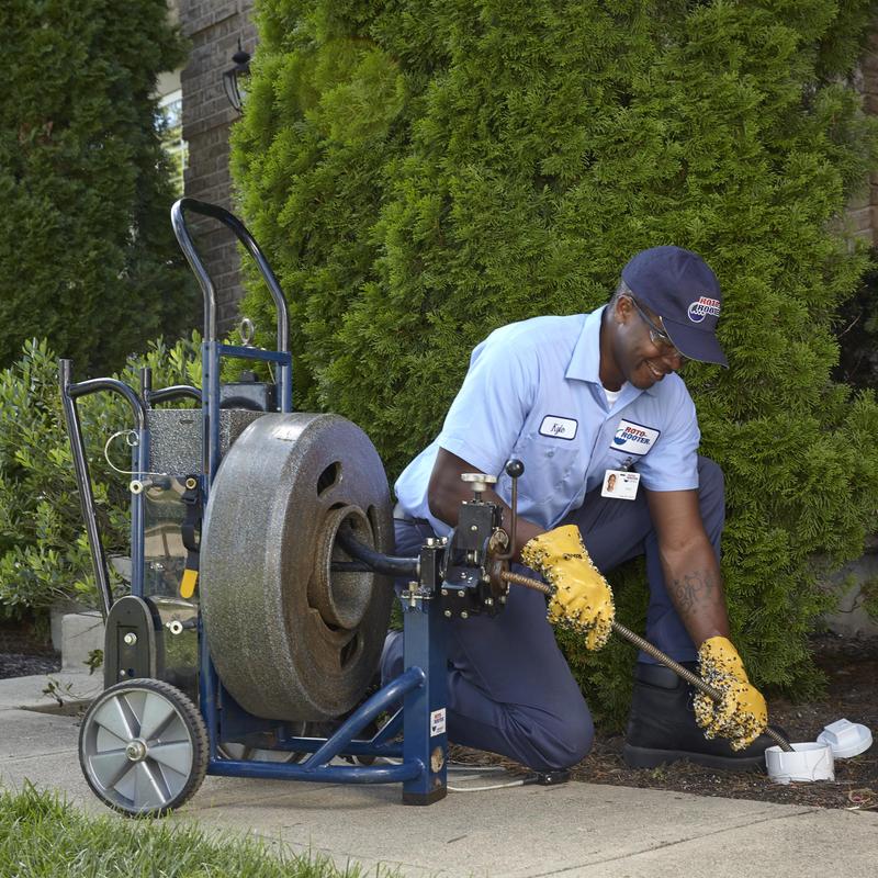 Main sewer line cleaning with rotary machine outdoors