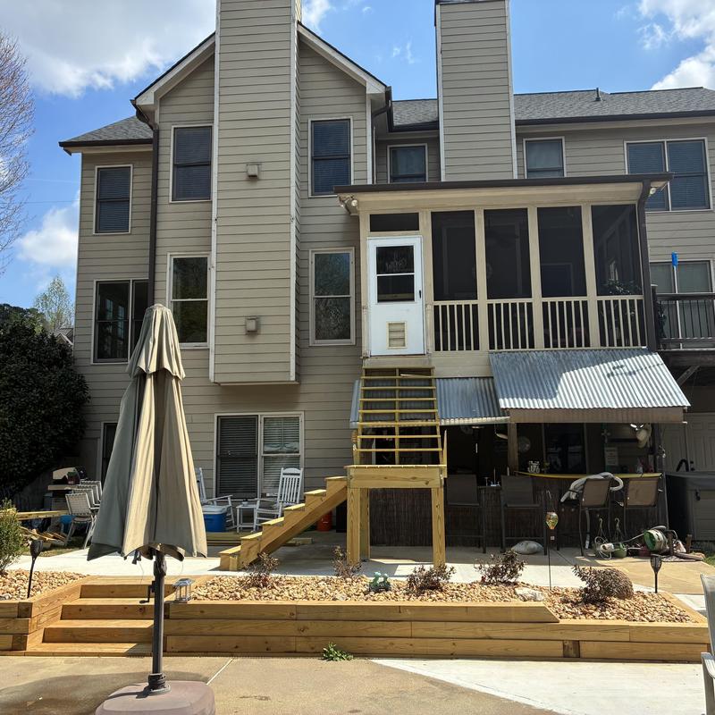 Wooden staircase with metal post supports and landing