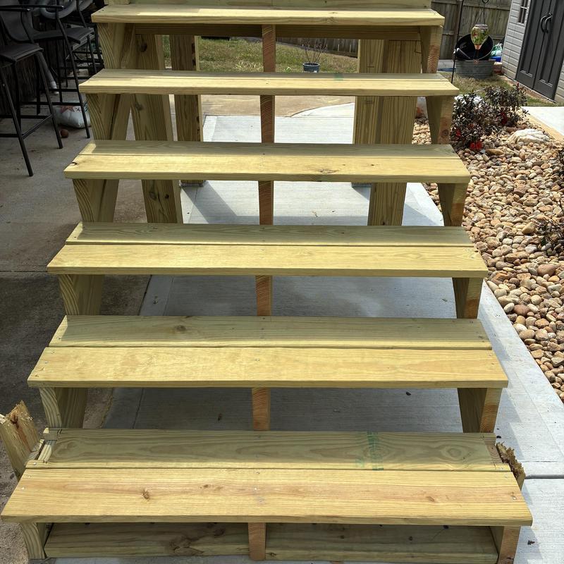 Wooden staircase with reinforced posts on concrete slab