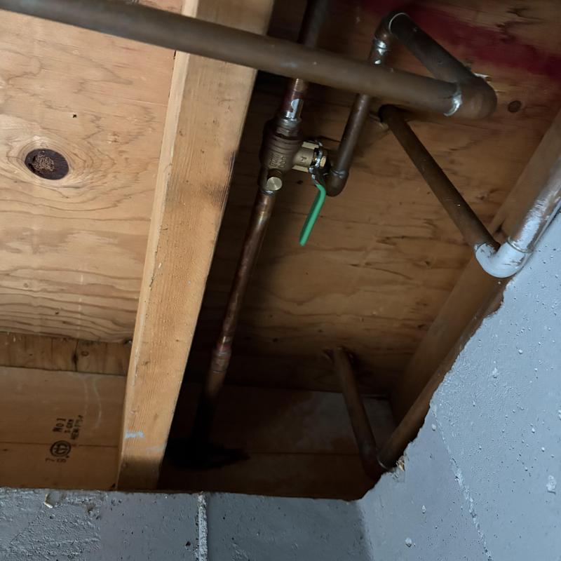 Outside faucet with green handle shut-off valve and piping