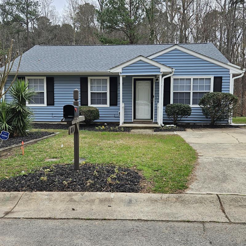 Vinyl siding and lawn before home renovation