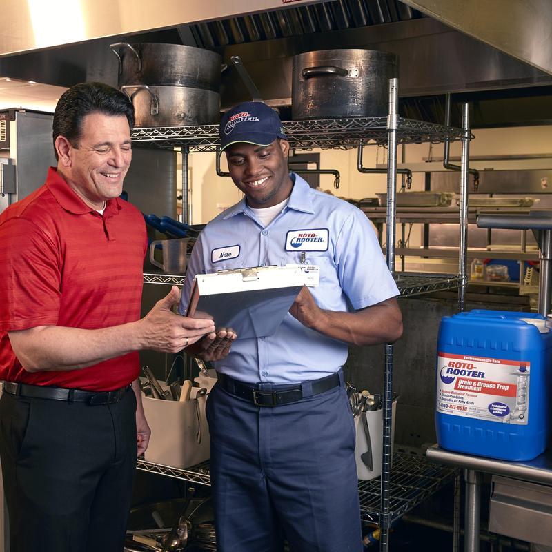 Restaurant floor drain with plumber and client discussing plan