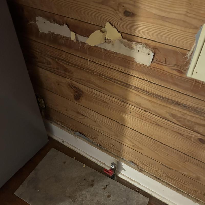 Gas wall unit pipe capped off below wooden paneling