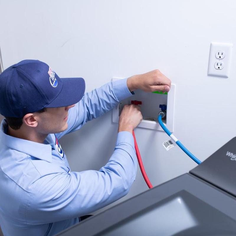 Washer drain and water lines with plumber working