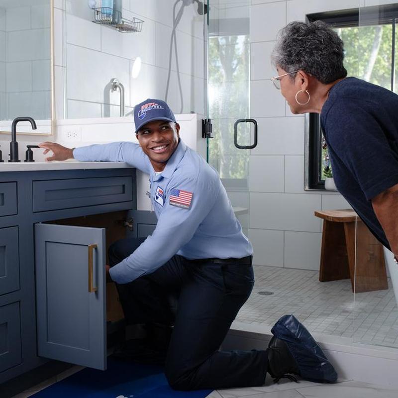 Bathroom sink plumbing inspection by technician
