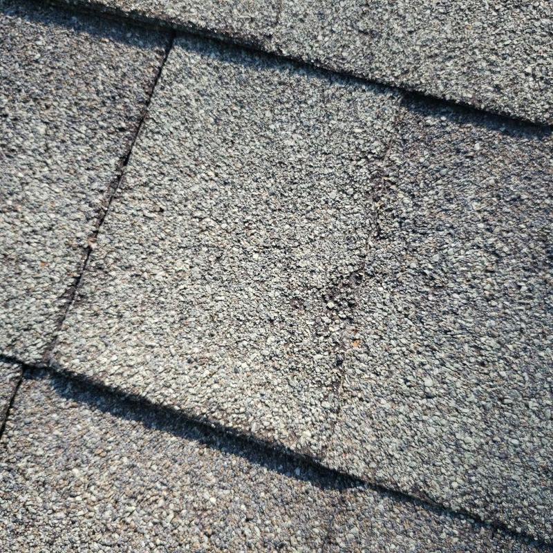 Asphalt shingle roof with visible wear and damage