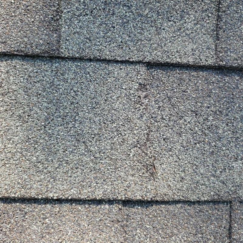Asphalt roof shingles showing wear and damage