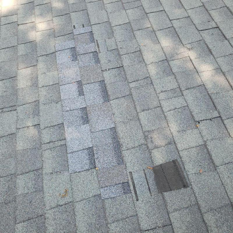 Asphalt shingle roof with damaged and missing shingles