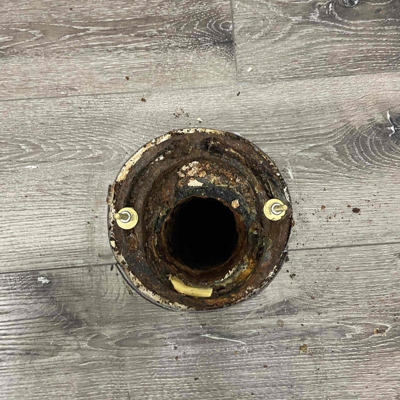 Toilet flange with rust and damage on wood floor Toilet flange with rust and damage on wood floor