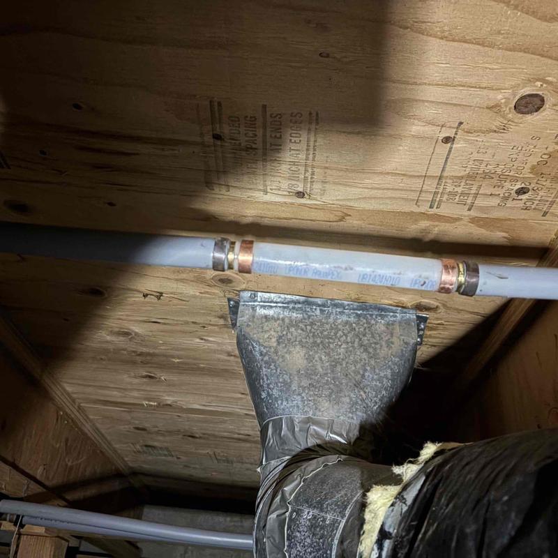 Copper water pipe with connectors under wooden floor joists Copper water pipe with connectors under wooden floor joists