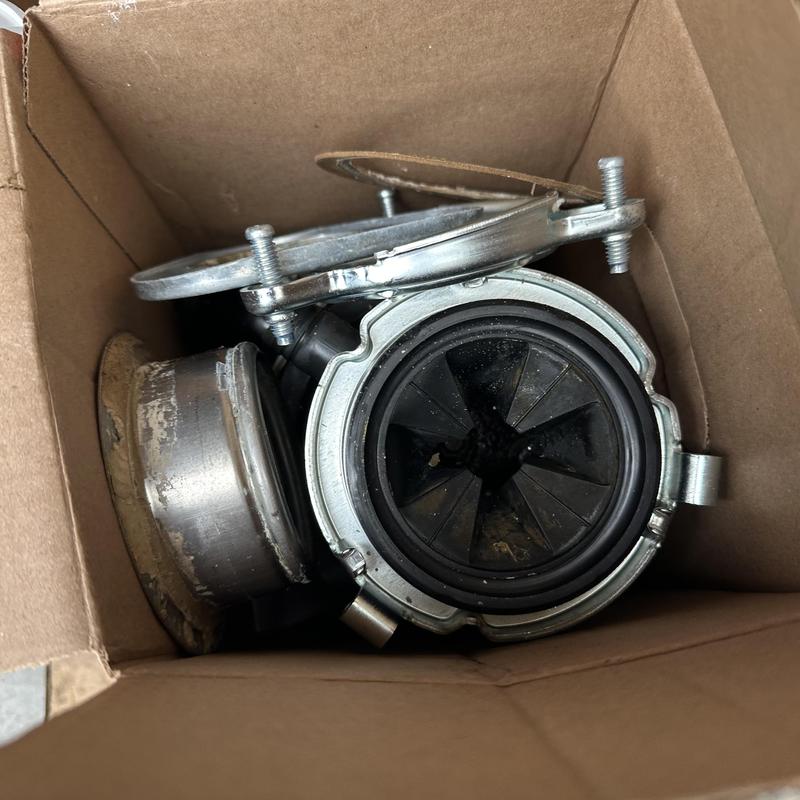 Garbage disposal replacement parts in cardboard box