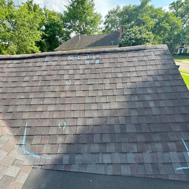 Architectural shingles with hail damage marked on roof