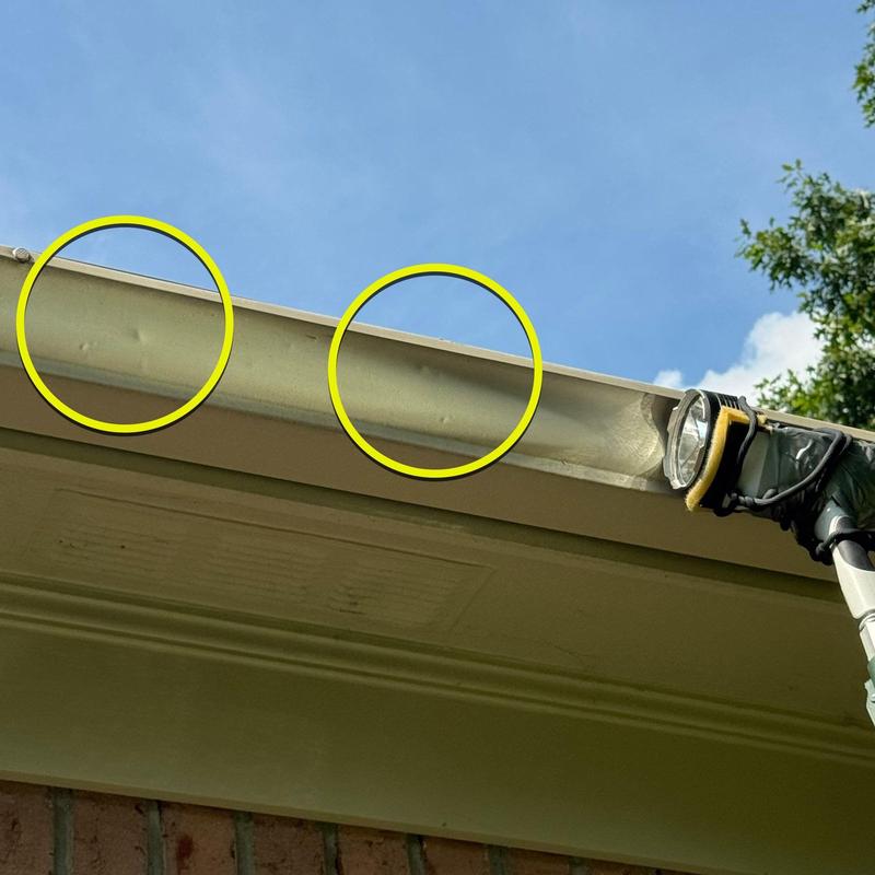 Metal gutter dents from hail damage highlighted