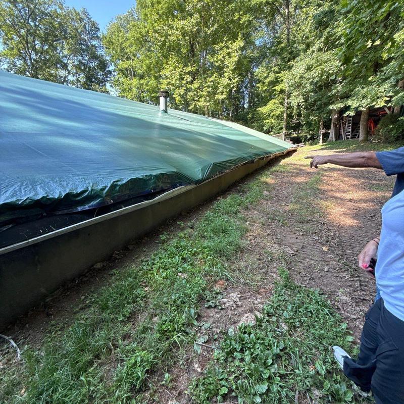 Roof tarp covering for storm protection in wooded area