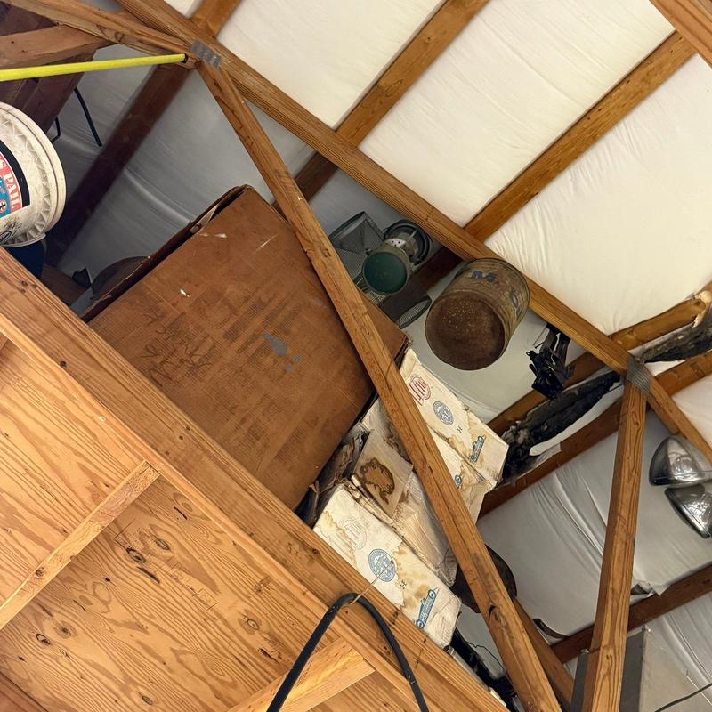 Wood roof truss with stored items in attic space