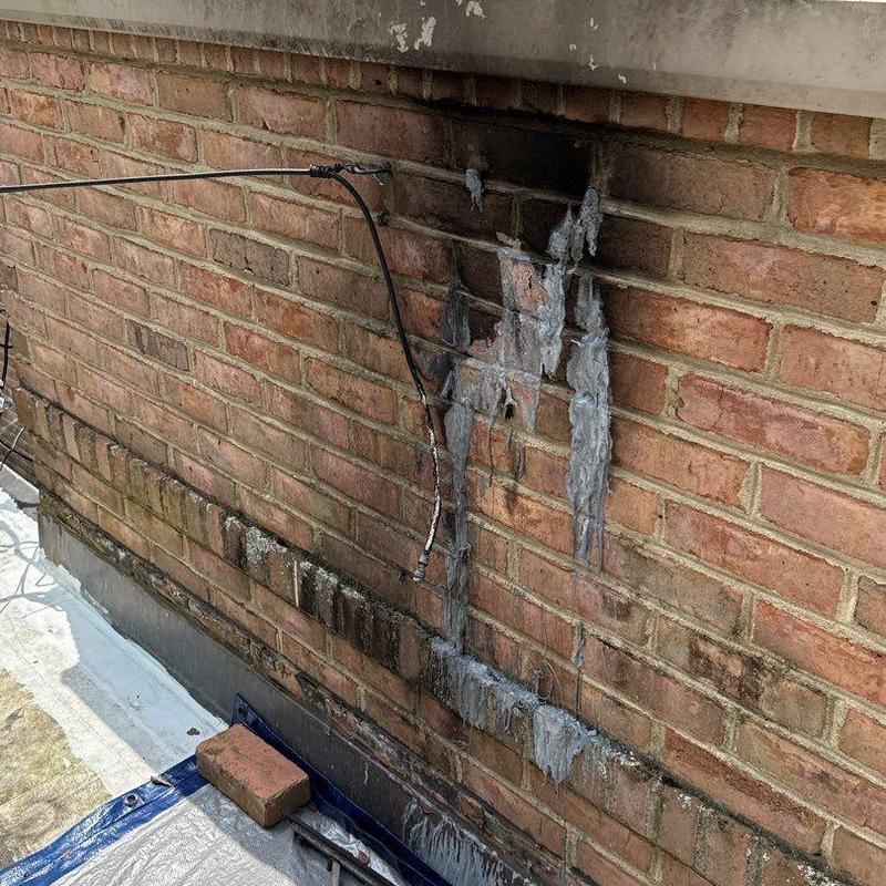 Brick wall with melted sealant and exposed wiring