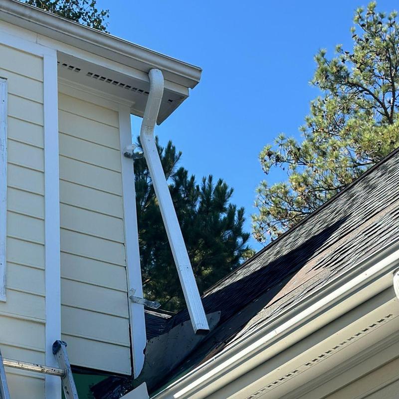 Downspout and damaged roof area after storm