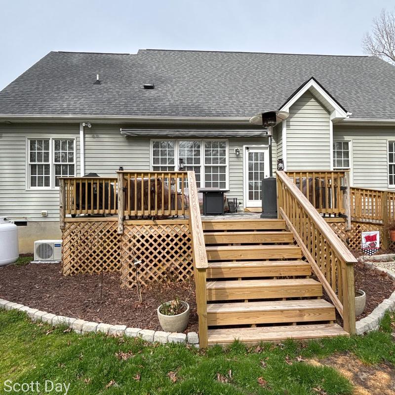 Wooden deck with stairs and railing in backyard