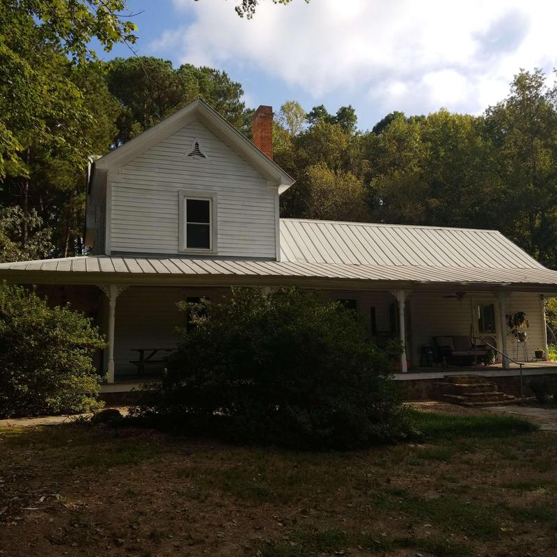 Metal roof on 1910 farmhouse with porch and chimney