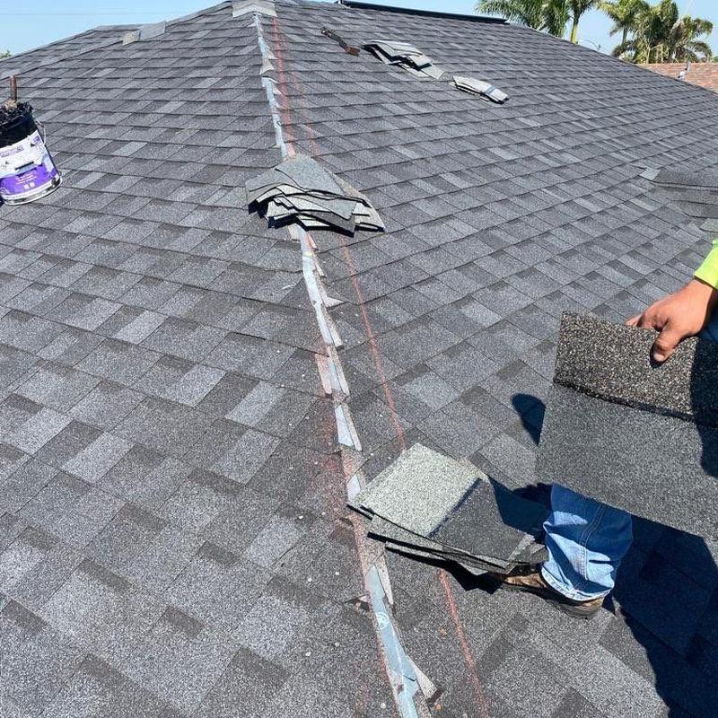 Hip cap shingles on roof with loose shingle stacks