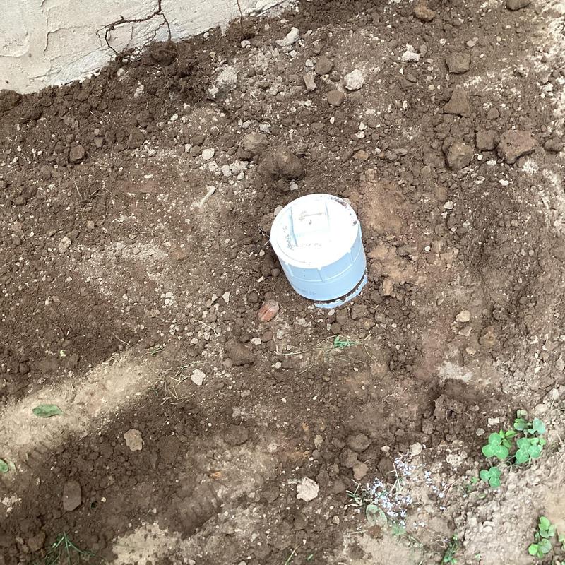 Two-way clean out pipe installation in soil near foundation