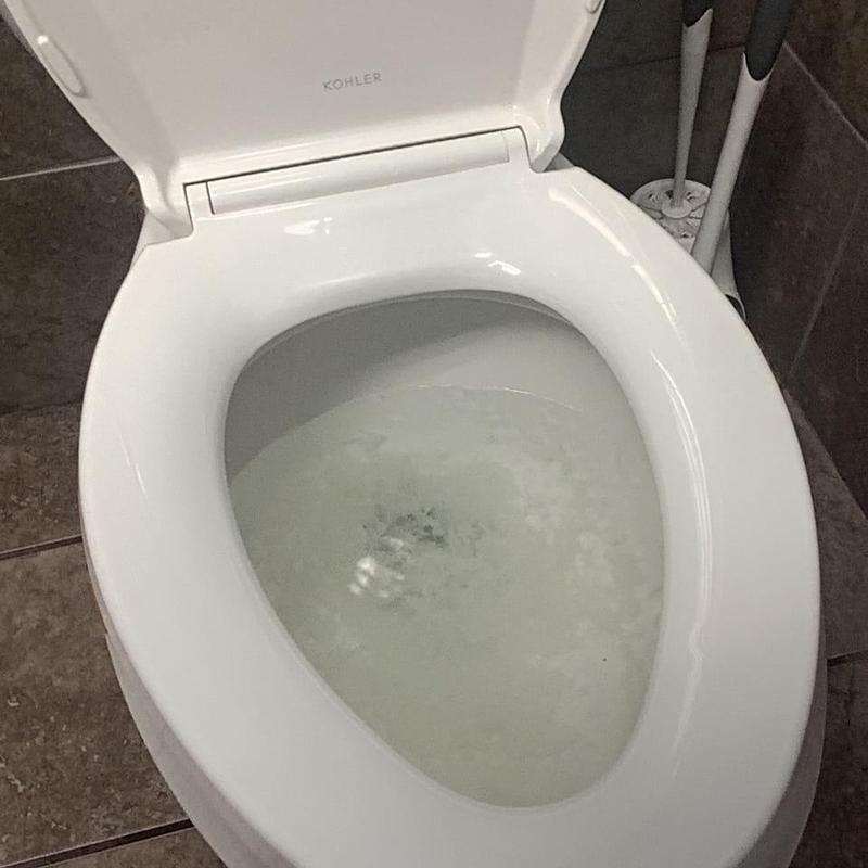 Commode bowl with slow draining water in warehouse restroom