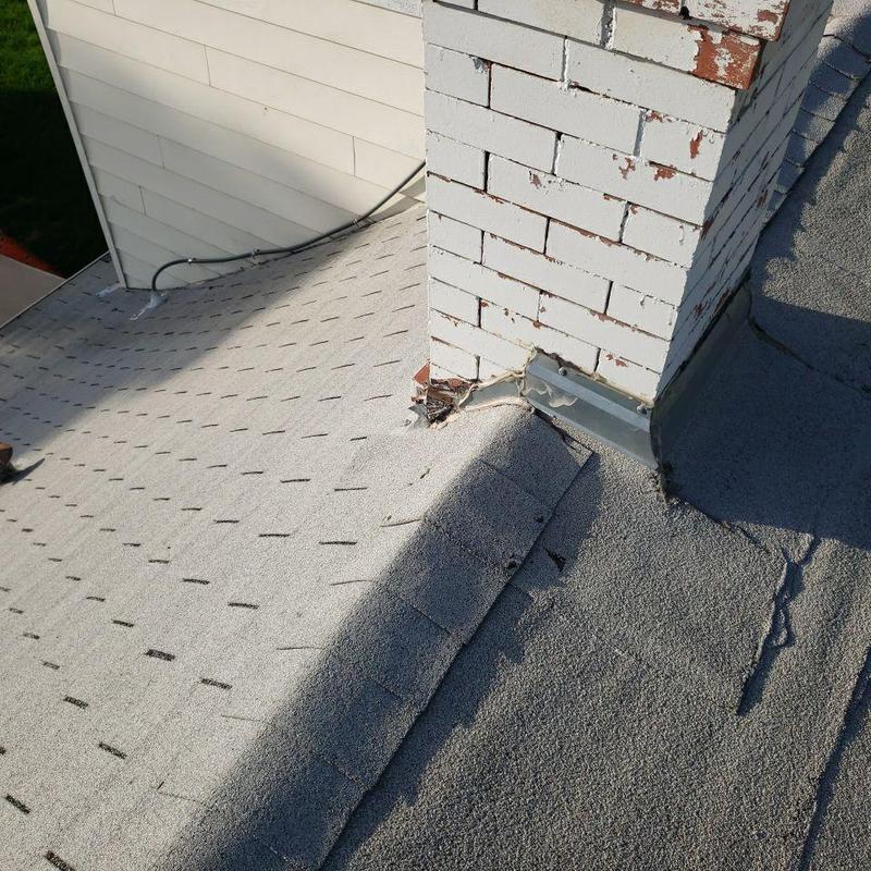 Chimney flashing with visible sealant and damage