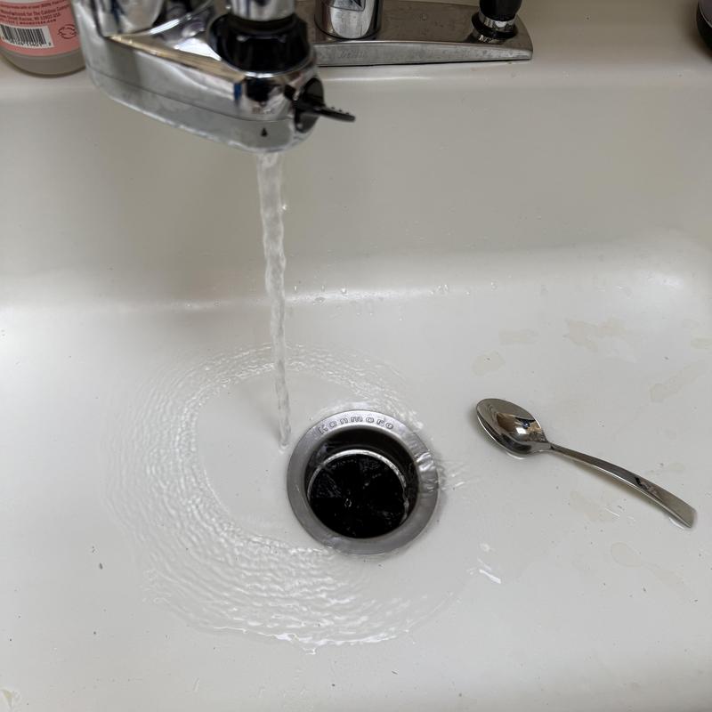 Kitchen sink drain flowing water after cleaning blockage