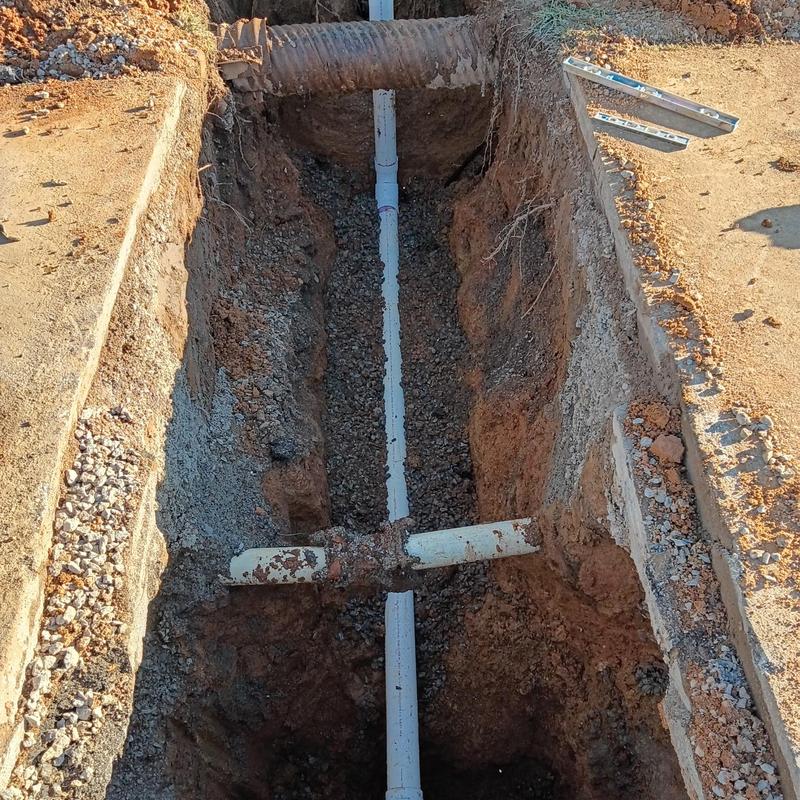Sewer pipe replacement trench with old and new pipes