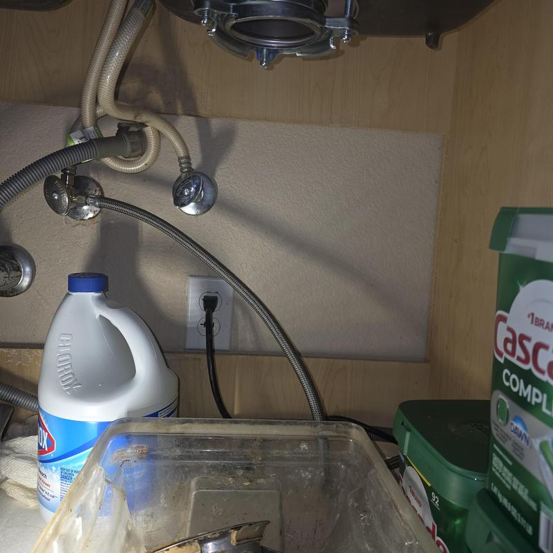 Garbage disposal mounting assembly with water lines under sink