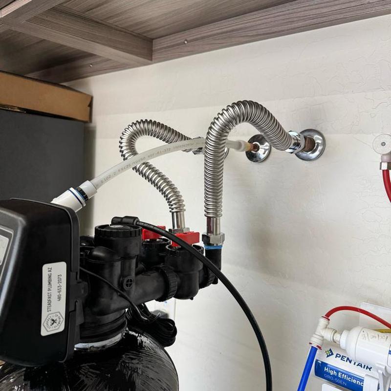 Whole home water softener with flexible water lines