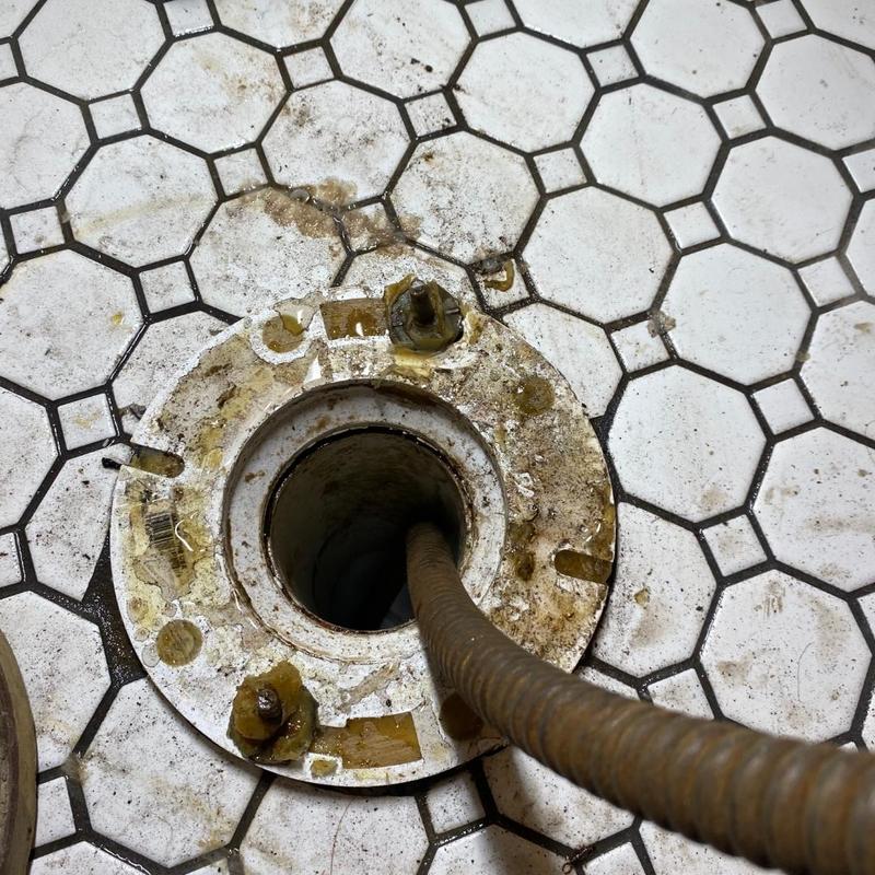Toilet flange with sewer cable in tiled floor