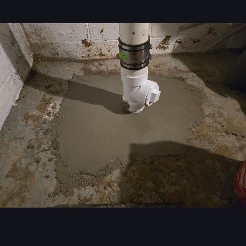 PVC sewer cleanout pipe with fresh concrete patch