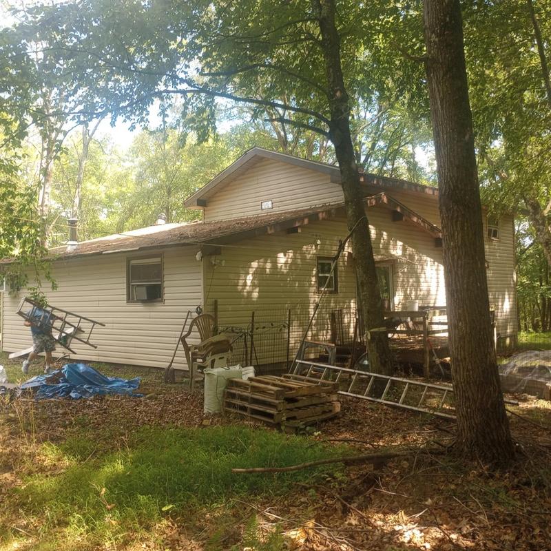 Shingles and flashing roof inspection at wooded home