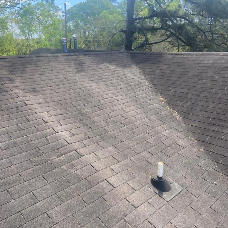 Asphalt shingle roof with vent pipe and tree shadows