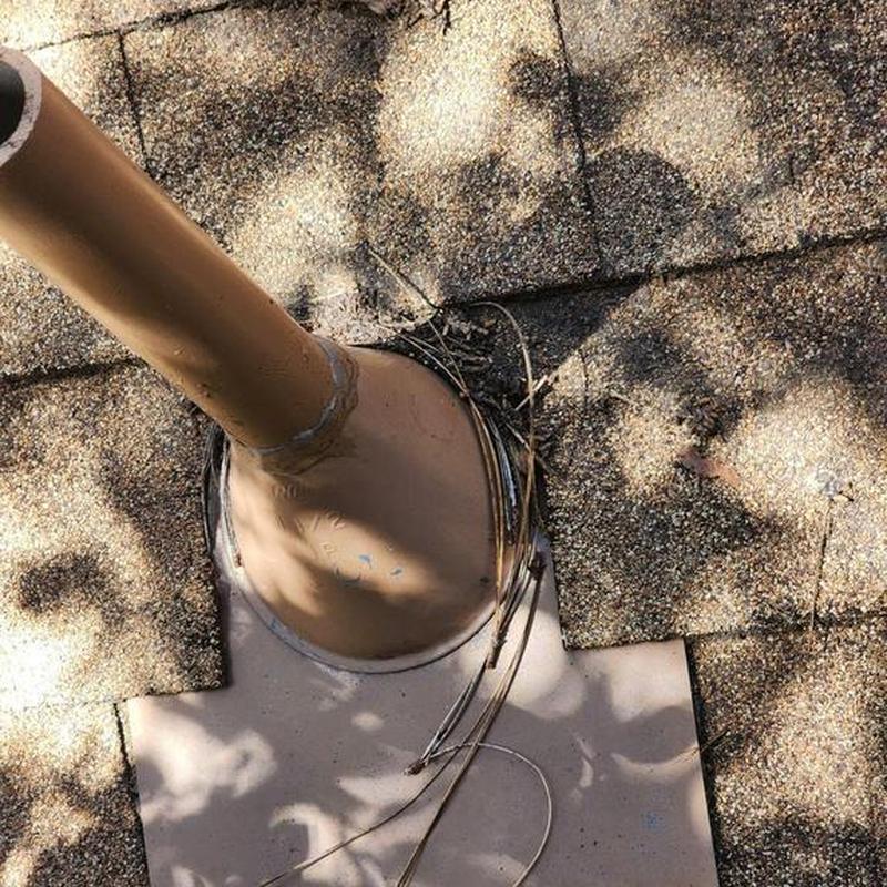 Vent pipe flashing on asphalt shingle roof with debris