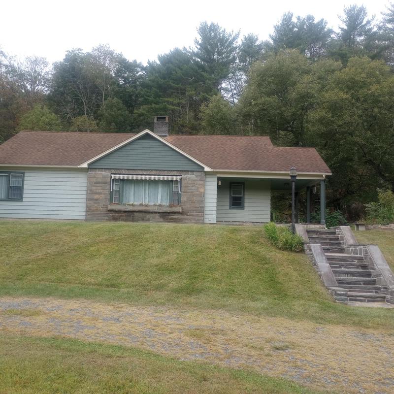 Asphalt shingle roof on single-story home with lawn