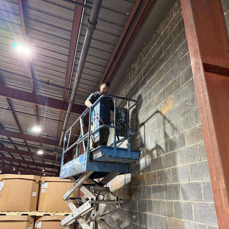 Industrial warehouse wall inspection on scissor lift Industrial warehouse wall inspection on scissor lift